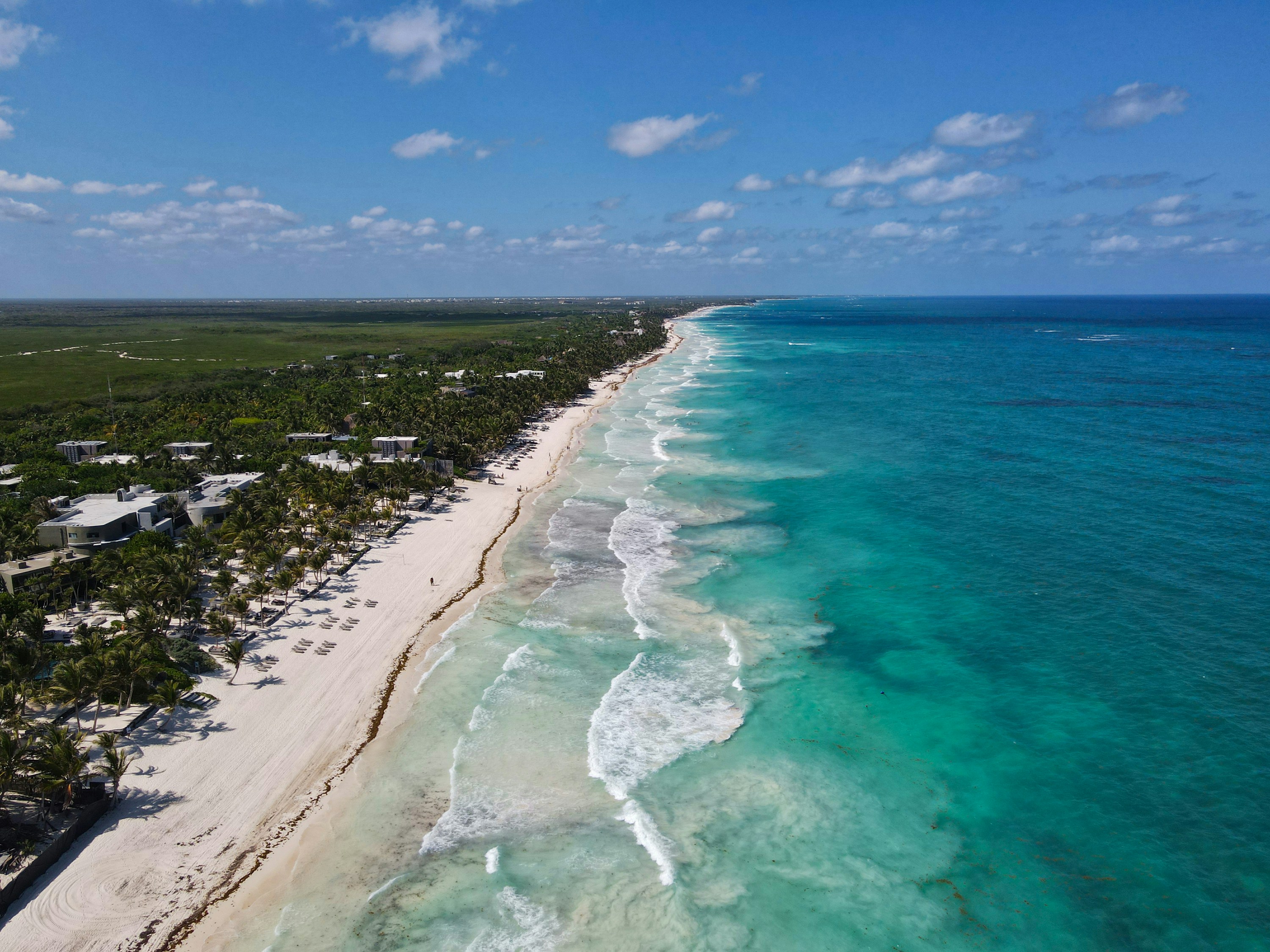 An aerial view of the coastline and turquoise water at Tulum